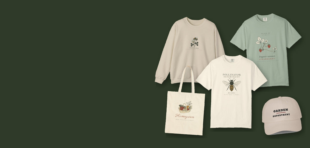 Garden Department hero: Leave the Clover Crewneck in Sand, Strawberry Plate Tee in Bay, Pollinator Department Tee in Ivory, Homegrown Tote in Natural and Garden Department Dad Hat in Stone